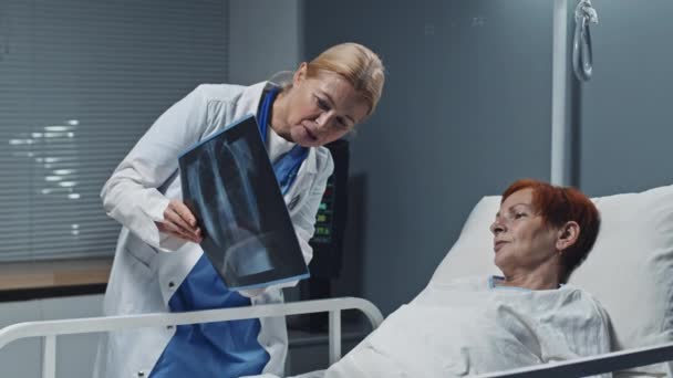 Mediana Larga Rubia Madura Doctora Vistiendo Bata Médica Mostrando Radiografía — Vídeos de Stock