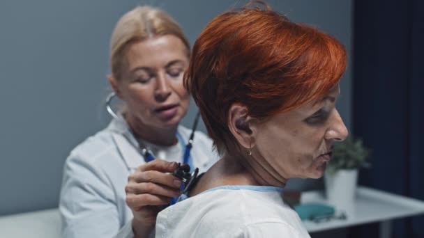 Medium Close Mature Female Doctor Using Stethoscope Back Red Haired — Video