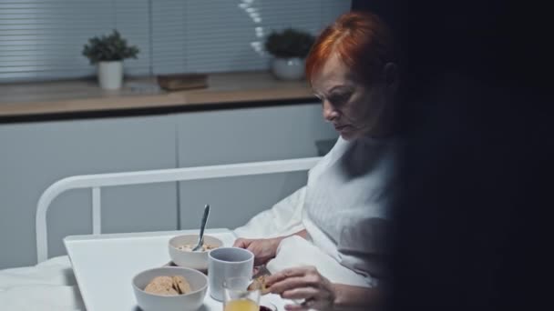 Kızıl Saçlı Beyaz Bir Kadının Solunda Hastane Odasında Yatakta Oturmuş — Stok video