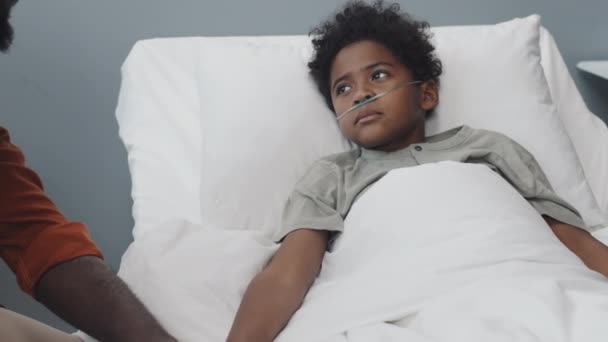 Tilting Young Black Man Eyeglasses Sitting Bed Hospital Ward Daytime — Video Stock