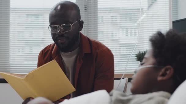 Χαμηλή Γωνία Του Νεαρού Αφρο Αμερικανού Πατέρα Διαβάζει Βιβλίο Φωναχτά — Αρχείο Βίντεο