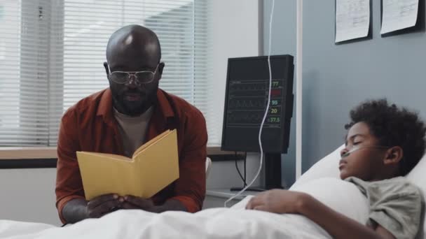 Medium Young Black Father Reading Book Out Loud Unconscious Little — Vídeo de Stock