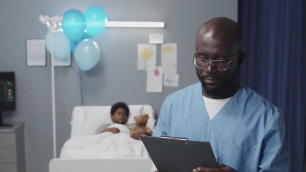 Грудь Молодого Афроамериканского Медбрата Комбинезоне Очках Стоящего Больничной Палате Размытого — стоковое видео