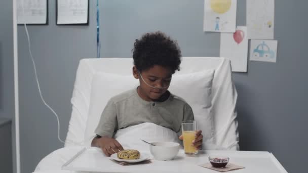 Mediano Chico Afroamericano Lindo Sentado Cama Del Hospital Desayunando Bebiendo — Vídeos de Stock