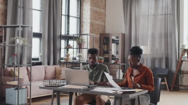 Молодые Афроамериканцы Сидящие Днем Письменным Столом Гостиной Пользующиеся Портативным Компьютером — стоковое видео