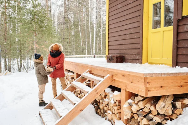 Young Black Man Winterwear Passing Firewood Woodpile Porch Country House — Foto Stock
