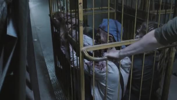 Soldier Shaved Head Transporting Zombies Cage Wheels Dark Basement Industrial — Vídeo de Stock