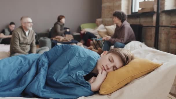 Medium Caucasian Tween Boy Sleeping Blue Blanket Cot Refuge Foreground — Stock Video