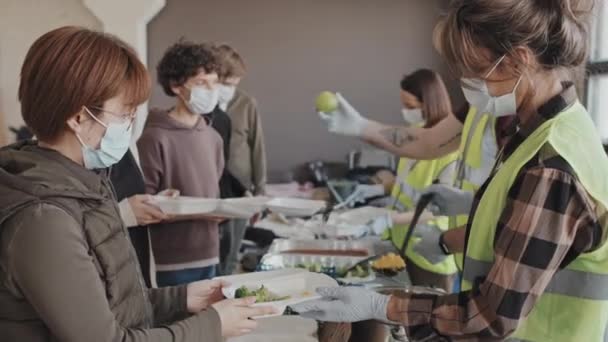 Zöld Mellényes Önkéntesek Arcmaszkos Önkéntesek Oldalnézete Akik Nappal Egészséges Vacsorát — Stock videók