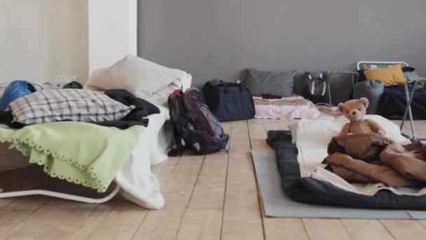 下午室内难民营 带个人物品的带个人物品的小床和床垫的低角度跟踪权 — 图库视频影像