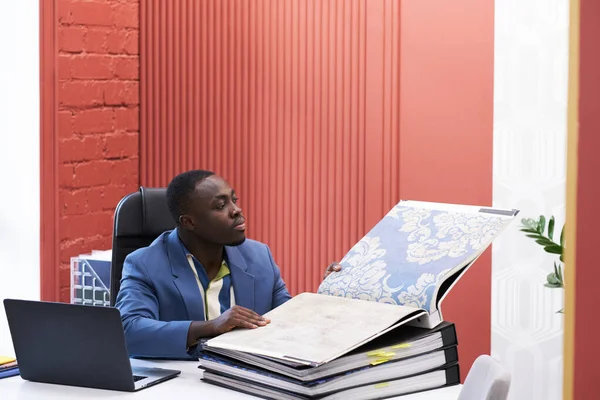African Young Designer Examining Sample Fabric Folder Future Interior While — Zdjęcie stockowe