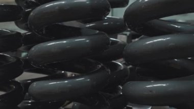 Tracking left view of large graphite grey reoil springs for bulldozers on factory