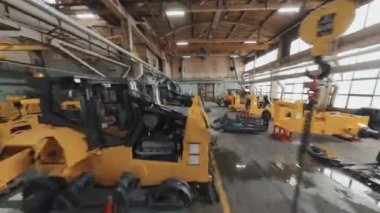 Drone tracking view of bulldozers in progress at factory in afternoon