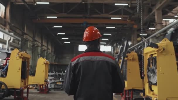 Rear Tracking Workman Orange Hat Walking Heavy Machinery Production Plant — ストック動画