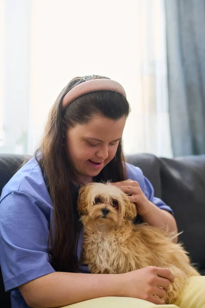 Szczęśliwa Dziewczyna Zespołem Downa Przytulanie Puszysty Pies Siedzi Kolanach Podczas — Zdjęcie stockowe