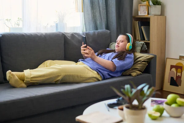 Sendromlu Genç Bir Kadın Oturma Odasında Kanepede Dinlenirken Akıllı Telefon — Stok fotoğraf