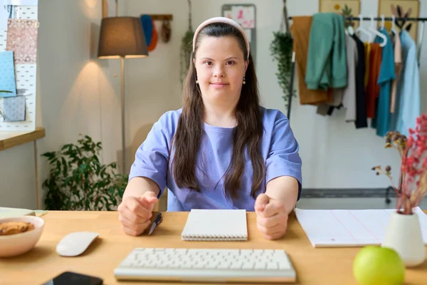 快乐的患有唐氏综合症的年轻女性坐在电脑前的桌子旁 准备上在线课程 看着你 — 图库照片