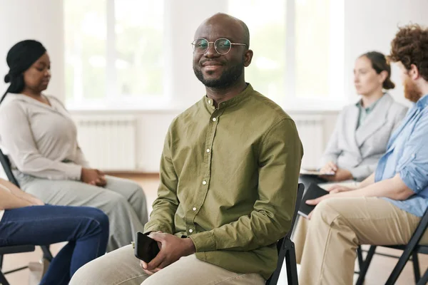 Feliz Joven Negro Con Teléfono Inteligente Sentado Frente Los Pacientes — Foto de Stock