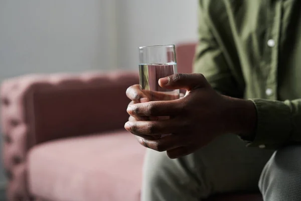 Руки Молодого Афроамериканця Який Тримає Склянку Води Сидячи Дивані Офісі — стокове фото