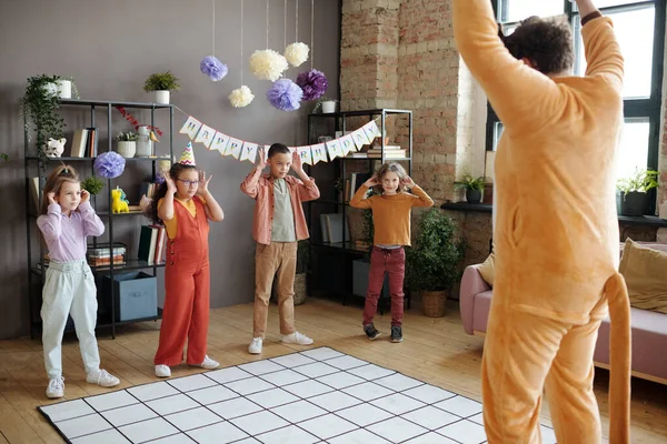 生日晚会期间 一群孩子们穿着动物服装和动画师一起在家里玩耍跳舞 — 图库照片