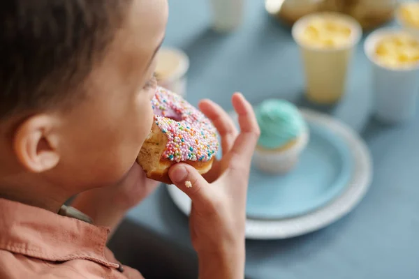 Close Van Kleine Jongen Bijten Geglazuurde Donut Terwijl Zitten Aan — Stockfoto