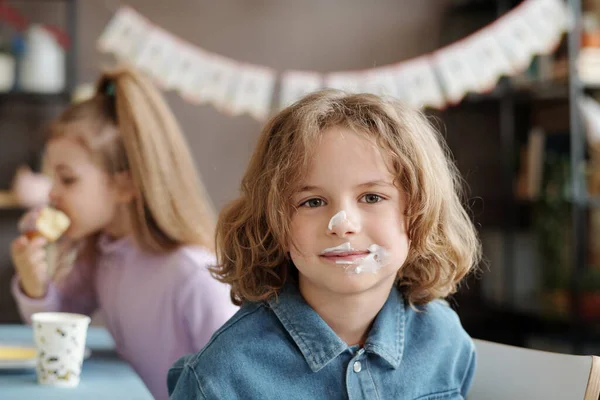 在派对上享用甜点时 一个长头发 脸上沾满糖霜的可爱小男孩在镜头前的画像 — 图库照片