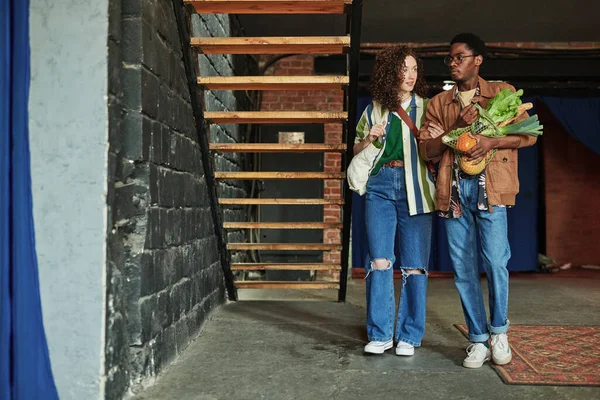 Fiatal Tartja Barátját Friss Zöldségekkel Bevásárlószatyorban Karjánál Miközben Mindketten Lakásukban — Stock Fotó