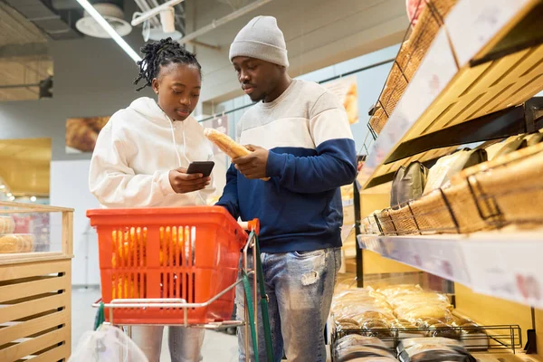 Joven Negro Hombre Mujer Mirando Través Lista Compras Teléfono Inteligente — Foto de Stock