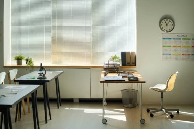 Teneffüs sırasında boş sınıf, bilgisayar ve diğer malzemeler öğretmenlerin işyeri ve mikroskop ile donatılmış iki masa.