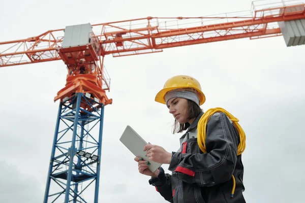 Jonge Serieuze Vrouwelijke Ingenieur Werkkleding Beschermende Helm Kijken Naar Het — Stockfoto