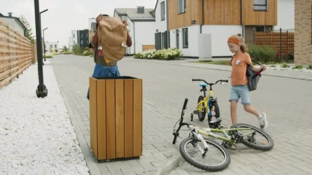기념하기 자전거를 거리에 어린이들을 그들의 교과서와 쓰레기통에 버리는 — 비디오