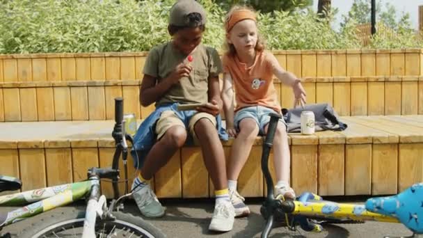 Полный Снимок Двух Скучающих Детей Подростков Сидящих Скамейке Парке Афроамериканский — стоковое видео