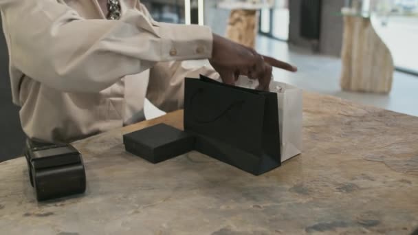 Mittelteil Zeitlupe Eines Verkäufers Der Schmuckschatullen Schwarz Weiße Einkaufstüten Steckt — Stockvideo