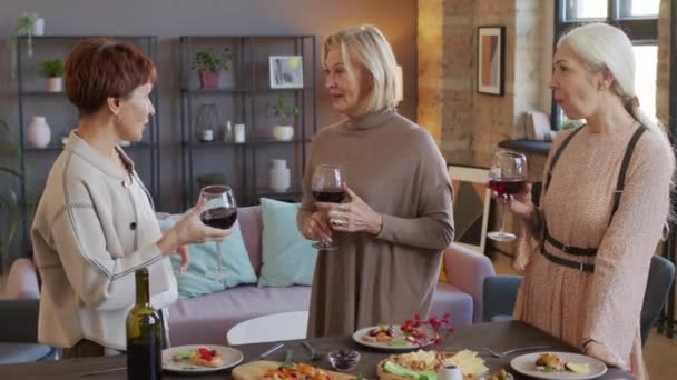 Drei Gut Aussehende Reife Frauen Stoßen Mit Gläsern Rotwein Während — Stockvideo