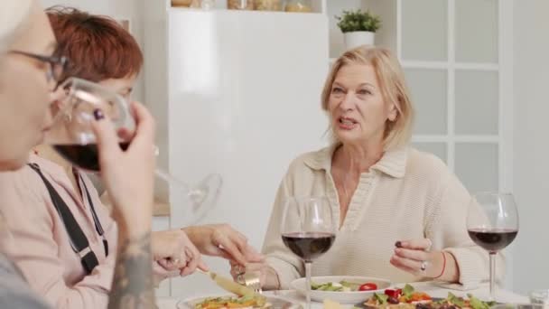 Tres Mujeres Adultas Bebiendo Vino Tinto Charlando Mientras Cenan Juntas — Vídeo de stock