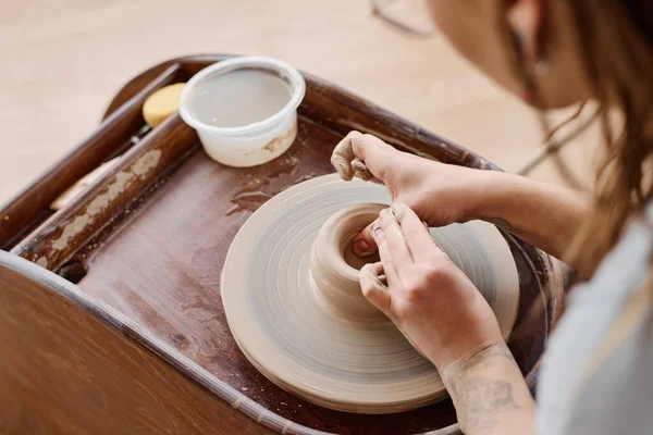 新黏土罐或壶上部分的年轻有才华的工匠或陶工在车间用陶器轮工作时的手 — 图库照片