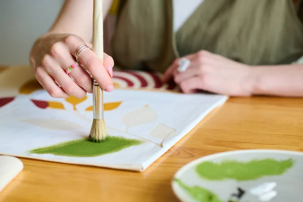 新しい抽象絵画を作成しながら 紙に緑の水彩を入れて筆で若い創造的な女性アーティストの手 — ストック写真