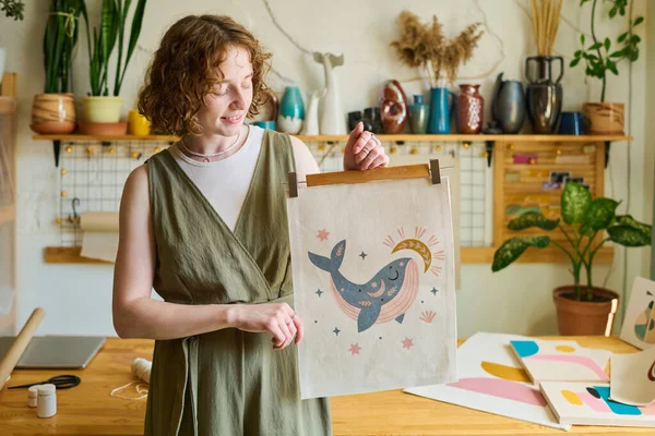 スタートと月に囲まれたクジラの手作り刺繍を見ながら あなたにそれを示す幸せな若い創造的な女性アーティスト — ストック写真