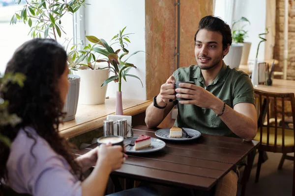 一个喝咖啡的男人和他的女朋友坐在桌前聊天 一边喝咖啡 一边吃着可口的甜点 — 图库照片