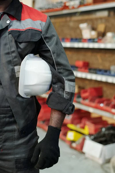 工厂或仓库的部分男工穿着工作服 戴着黑色防护手套 头戴安全帽 夹在弯曲的胳膊和腰间 — 图库照片