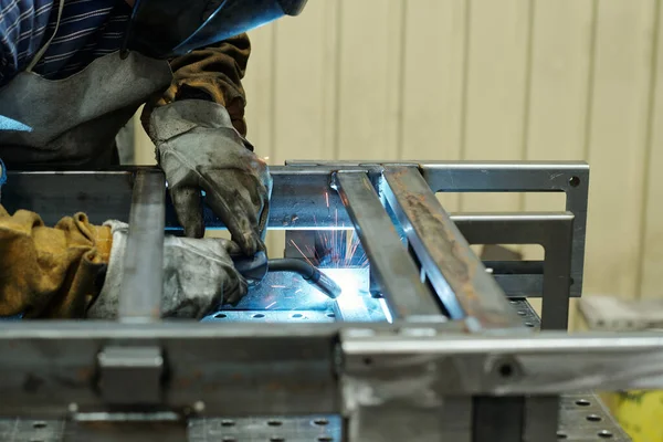 巨大な機械を生産する工業プラントの男性労働者の手袋をはめた手は ワークベンチと溶接金属部品に曲げ — ストック写真