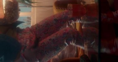 Renkli spor kıyafetli beyaz kadın eğitmen gündüz vakti spor salonunda siyah saçlı genç bayana yardım ediyor.