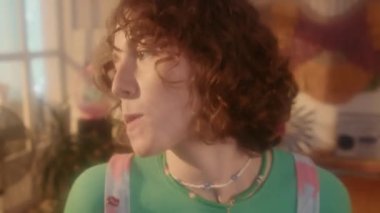 Kızıl Kafkasyalı sakız çiğneyen, 80 'lerin tarzında iç mekanıyla dans eden, gündüz eğlenen bir kız.
