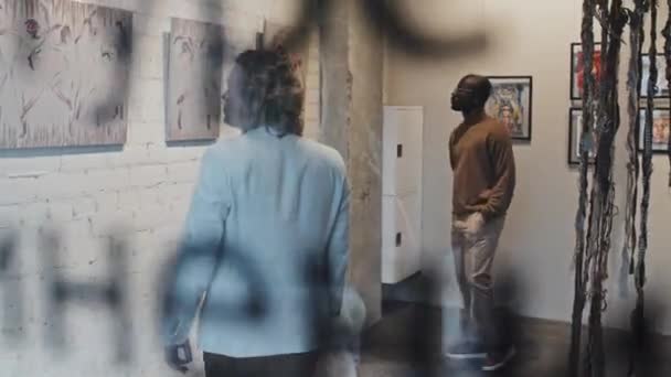 Melacak Kiri Dari Dua Pemuda Yang Cerdas Melihat Serangkaian Lukisan — Stok Video