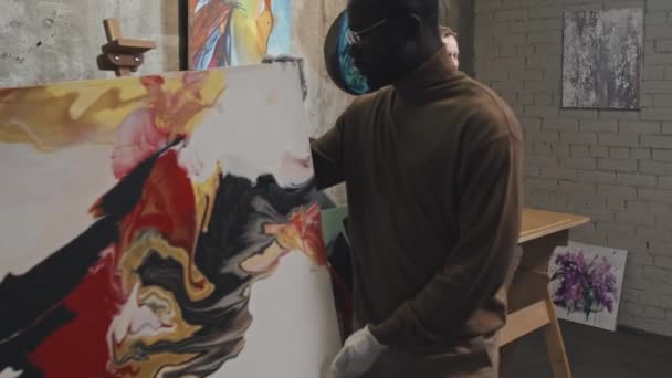 中等身材的金发白人男子身着正式西装 领衔拍卖会 手工艺者拿出抽象画 — 图库视频影像