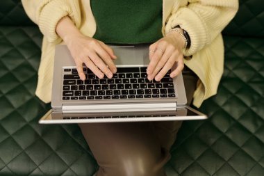 Genç iş kadını ya da kız öğrencinin el açısının üstünde dizüstü bilgisayarın üzerinde tuşlara basarak ofiste ağ kurarken