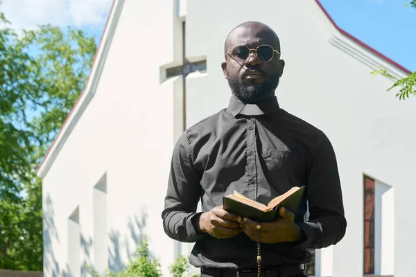 Młody Czarny Mężczyzna Koszuli Kołnierzem Duchownym Stojący Otwartą Biblią Przed — Zdjęcie stockowe
