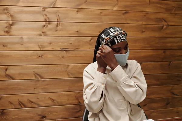 年轻的非洲裔美国女商人戴上防护面罩 以防止在办公室工作时感染 — 图库照片