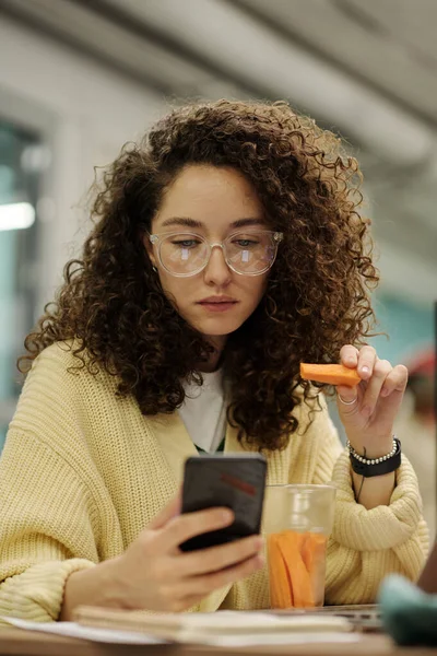 Young Serious Businesswoman Smartphone Eating Carrots Lunch Texting While Sitting — Stock Photo, Image