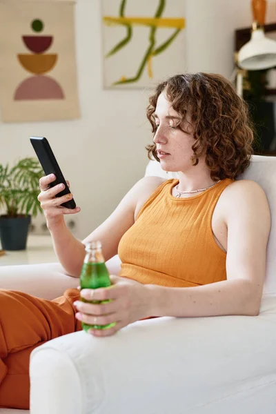 Menina Jovem Casualwear Rolagem Mensagens Texto Smartphone Beber Enquanto Relaxa — Fotografia de Stock